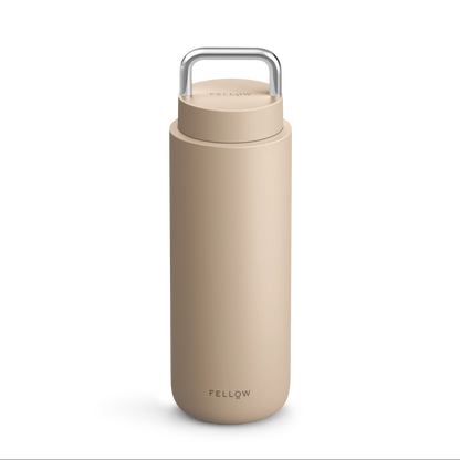 Beige Fellow Carter Carry Travel Mug with metal handle and "Fellow" on the front.