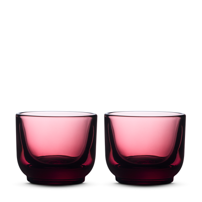 Two round Fellow Pirch Espresso Glasses in garnet on a plain white background.