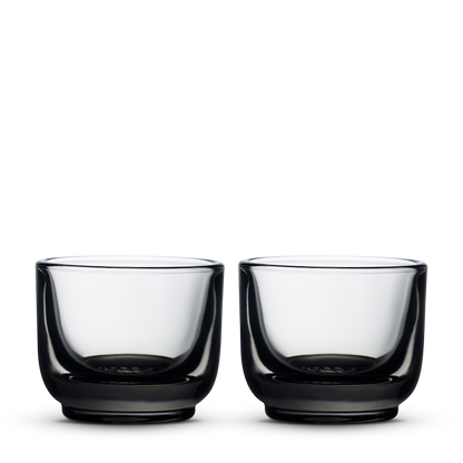 Two Fellow Pirch espresso glasses in smoke color on a plain white background.