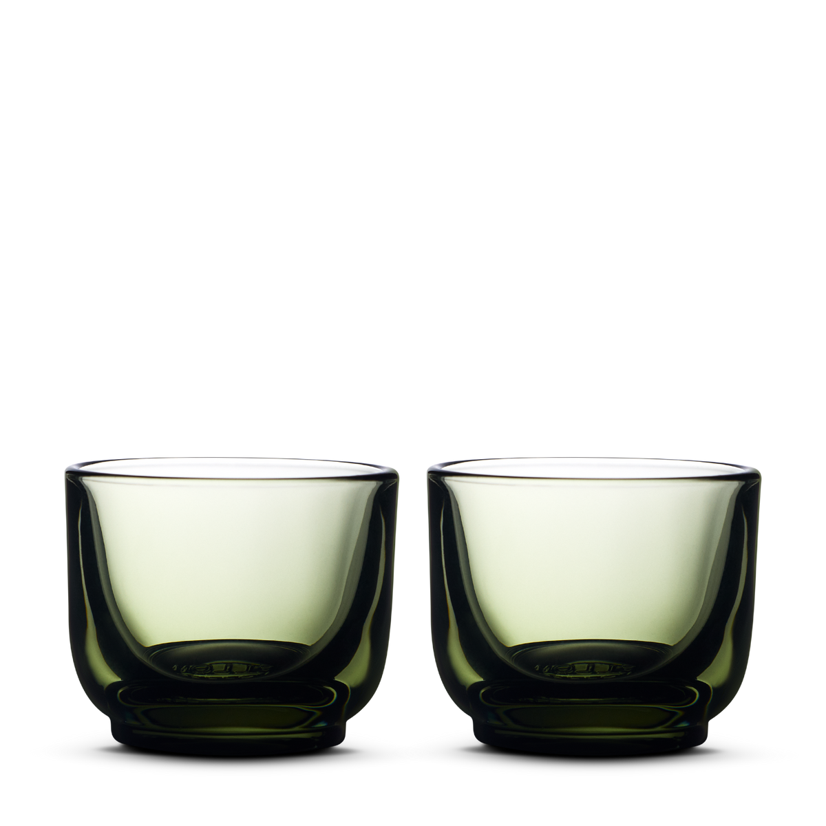 Two Fellow Pirch Espresso Glasses in Woodland color with curved sides on a white background.