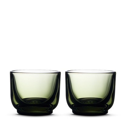 Two Fellow Pirch Espresso Glasses in Woodland color with curved sides on a white background.
