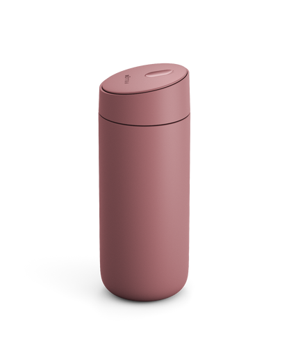 The Fellow Carter Slide Mug is a matte pink reusable travel mug with a rounded lid.