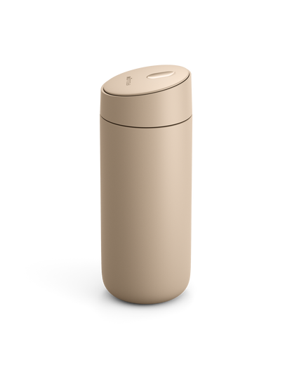 Fellow Carter Slide Mug in beige with oval push-button lid on a white background.