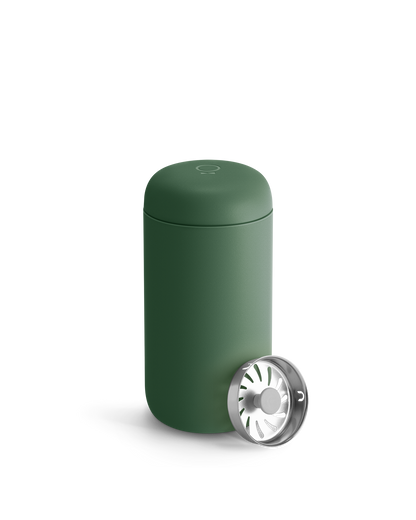Fellow Carter Move Mug in matte green with matching lid and metal strainer beside it.