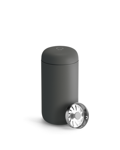 Matte black Fellow Carter Move Mug with round metal lid, partially open on a white background.