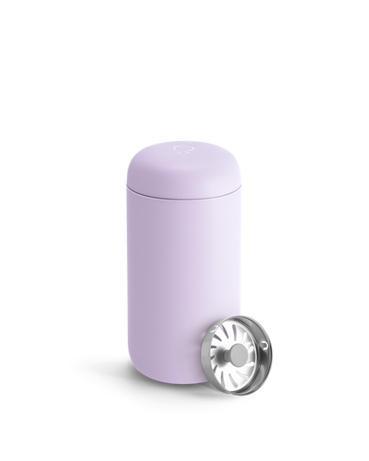 A light purple Fellow Carter Move Mug with a metal strainer leaning against it.
