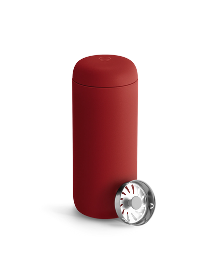 A matte red Fellow Carter Move Mug with a metal strainer on a white background.