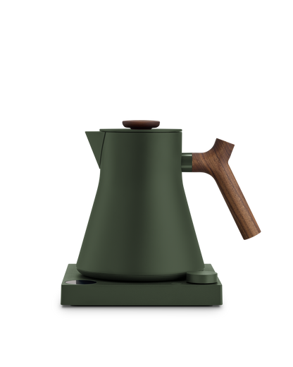 Fellow Corvo EKG Electric Kettle in matte green with wooden handle on a matching base.