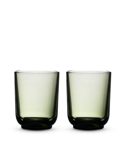 Two green Pirch Espresso Glasses by Fellow with rounded bases on a white background.