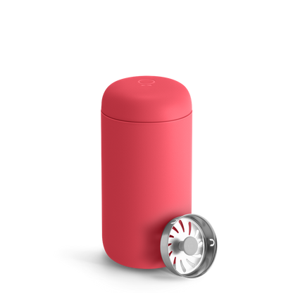 A coral Carter Move Mug by Fellow with a separate round metal lid on a white background.
