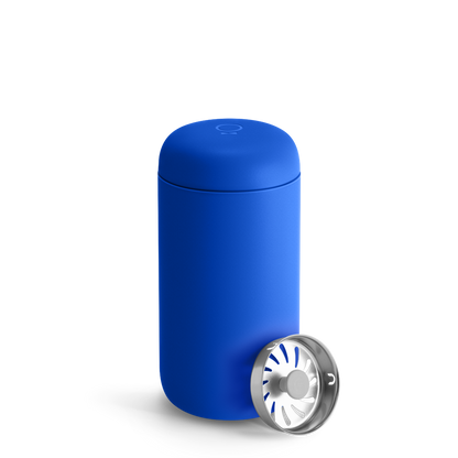 An Electric Cobalt Fellow Carter Move Mug sits next to a cylindrical metal infuser.