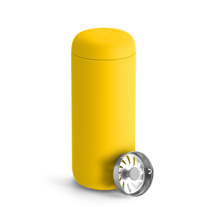 Fellow Carter Move Mug in Lemon Zest with rounded edges and a metal strainer in front.