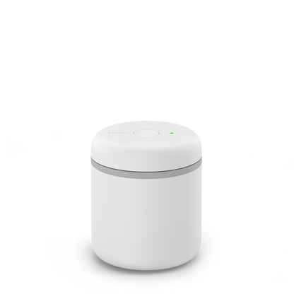 A small, round Fellow Atmos Vacuum Canister in matte white with a button and green indicator.